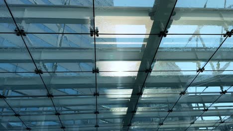 a clear glass ceiling structure with beams, sunlight shining through, harumi, tokyo