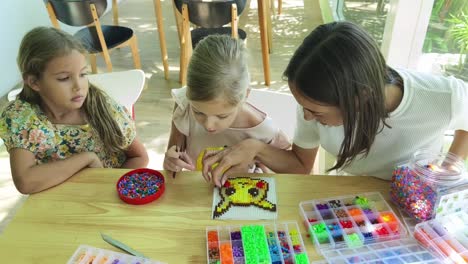 kids making pixel art with beads