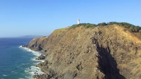 disparo aéreo de drones volando a lo largo de los acantilados de cape byron hacia el faro