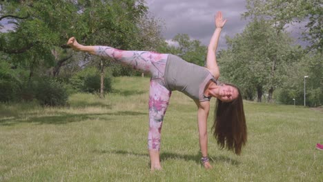 hermosa mujer sonriendo y haciendo yoga al aire libre en un día soleado