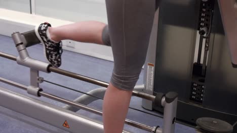 mujer usando una máquina de pesas en el gimnasio