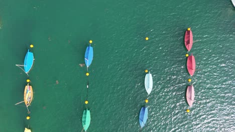 Blick-Von-Oben-Nach-Unten-Von-Der-Drohne-Mit-Bunten-Segelbooten,-Die-Festgemacht-Haben