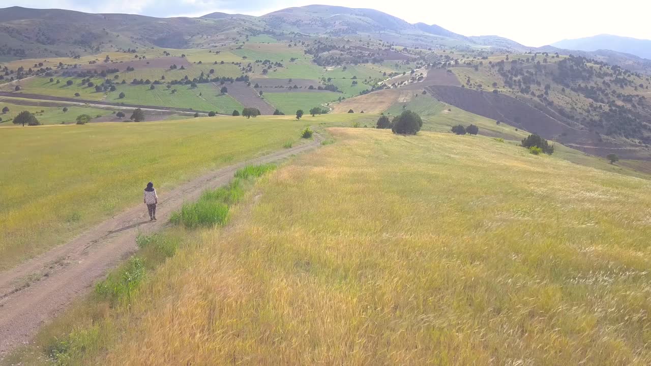 una agricultora iraní caminando por su granja de trigo