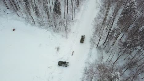 military vehicles in a snowy forest