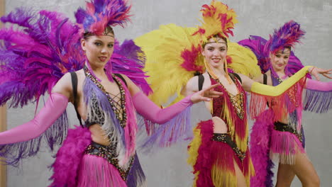 three cabaret dancers practicing the choreography in colorful outfits