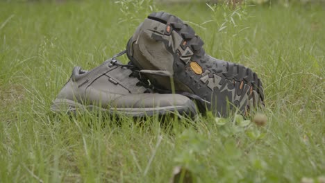 Wide-dolly-of-of-worn-hiking-shoes-in-a-grass-field