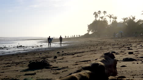 Zwei-Surfer-Mit-Surfbrettern-Unterhalten-Sich-Am-Strand-In-Silhouette-Am-Rincon-Point-In-Kalifornien,-Nachdem-Sie-Eine-Meereswelle-Gefangen-Haben