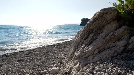 Strand-In-Griechenland,-Felsige-Klippe-Vor-Dem-Hintergrund-Der-Wellen-Des-Ionischen-Meeres