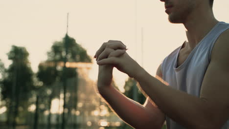 close up of a concentrated sportsman stretching wrists and hands 1