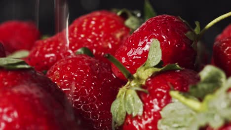 water droplets splashing onto red strawberries