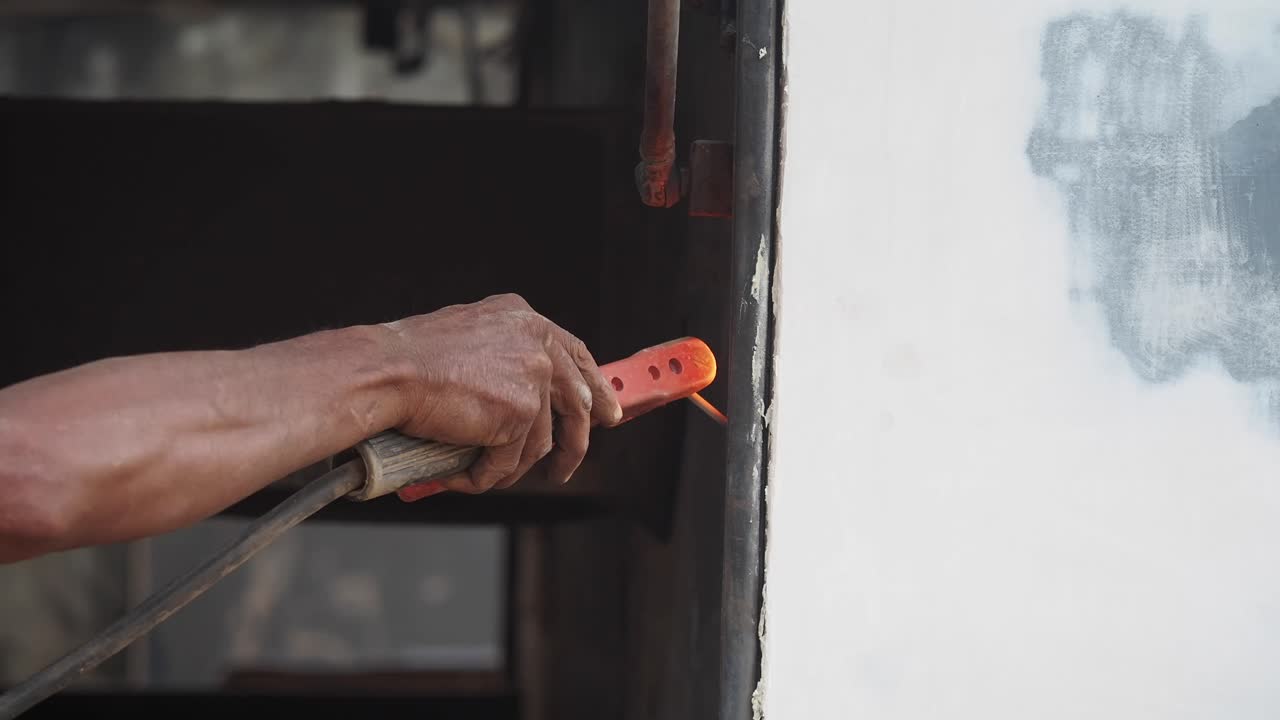 Close-up of a Welder's Hand Working on Metal