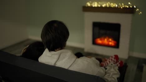 couple sitting at home by the fireplace embraced