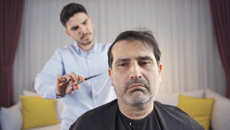 Young-caring-patient-at-home-is-shaving-his-hair.