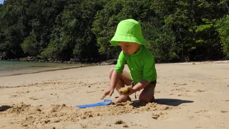 Young-kid-playing-with-sand-on-the-beach