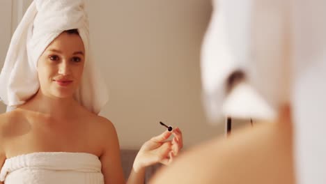 Woman-applying-mascara-on-eyelashes-in-bathroom