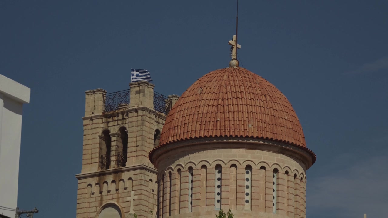 Cúpula de uma antiga igreja grega com bandeira a tremular em câmera lenta