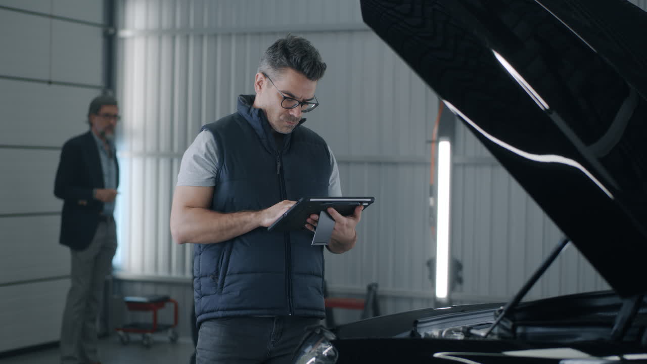 Car Mechanic Using Tablet for Diagnostics in Auto Repair Shop