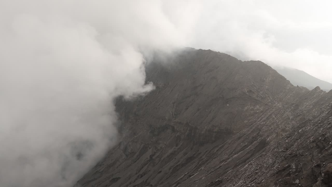 Bromo volcano crater covered in toxic plume smoke cloud low visibility Java island Indonesia