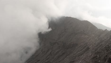 bromo volcano crater covered in toxic plume smoke cloud low visibility java island indonesia