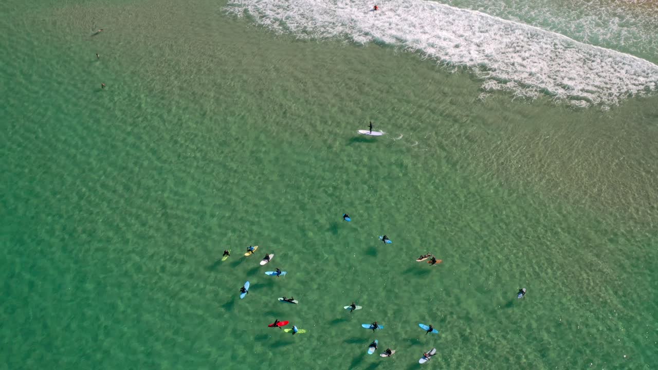 본다이 비치에서 서핑 - 호주 뉴사우스웨일즈 본다이의 푸른 바다에 떠 있는 서핑보드에 앉아 있는 서퍼들
