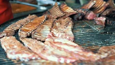 vista lateral hombre cocinando la cena. primer plano hombre asando costillas de cerdo.