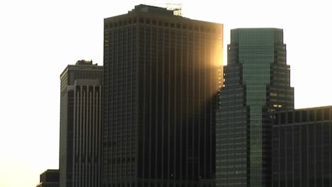 Impresionantes-Rascacielos-Vistos-Desde-El-Río-Hacia-El-Cielo-Con-La-Luz-Del-Sol-En-La-Esquina-De-Un-Edificio-En-La-Hora-Dorada