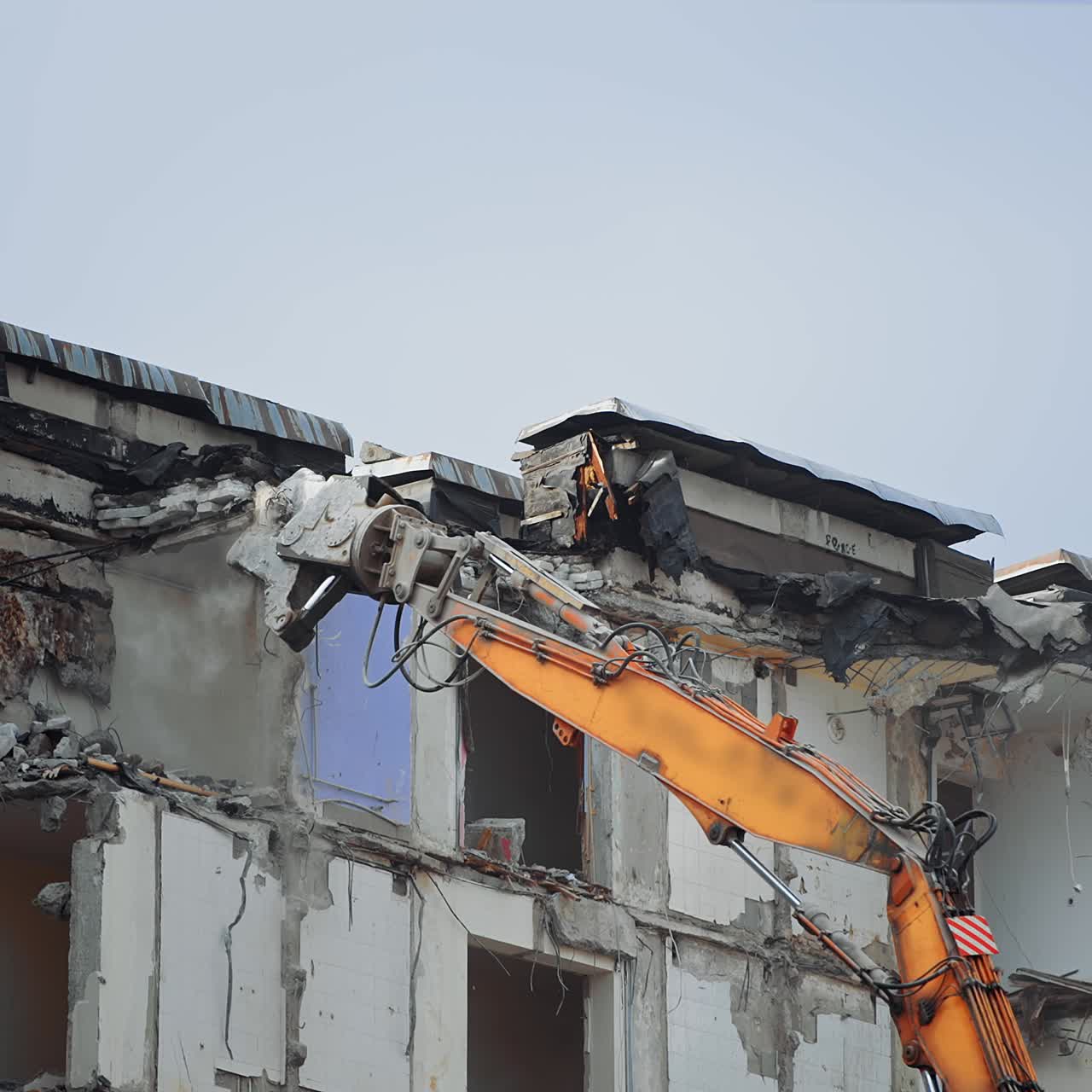 Special machine destroys a concrete house. Excavator machine with hydraulic crashers at demolition of the house