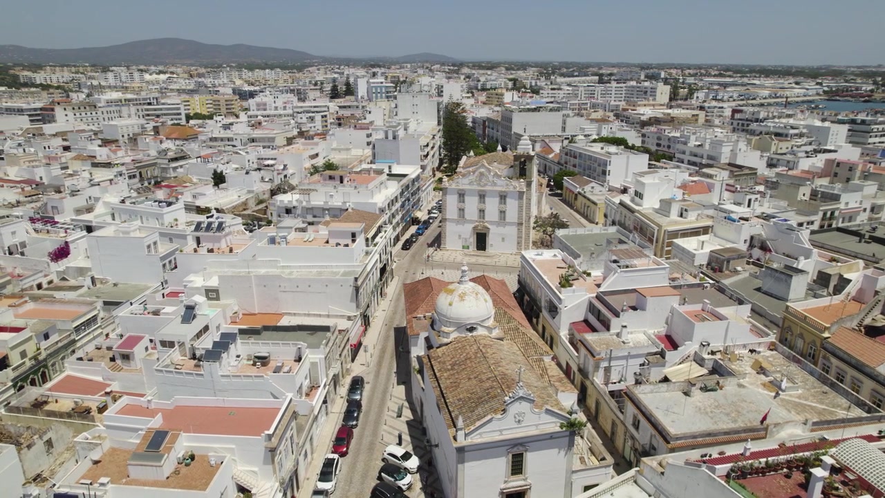 Igreja e Freguesia de Olhão em Portugal, órbita aérea sobre edifícios de tons neutros
