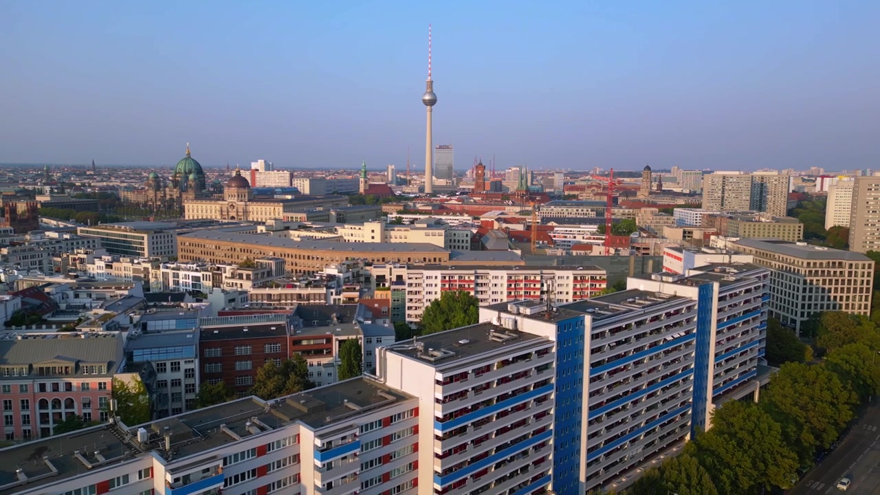 Berlins bybillede med Byslot, tv-tårn, domkirke, Røde Rådhus og SED's Centralkomité badet i gyldent lys. Unikt luftfoto med droneflyvning i omvendt retning.
