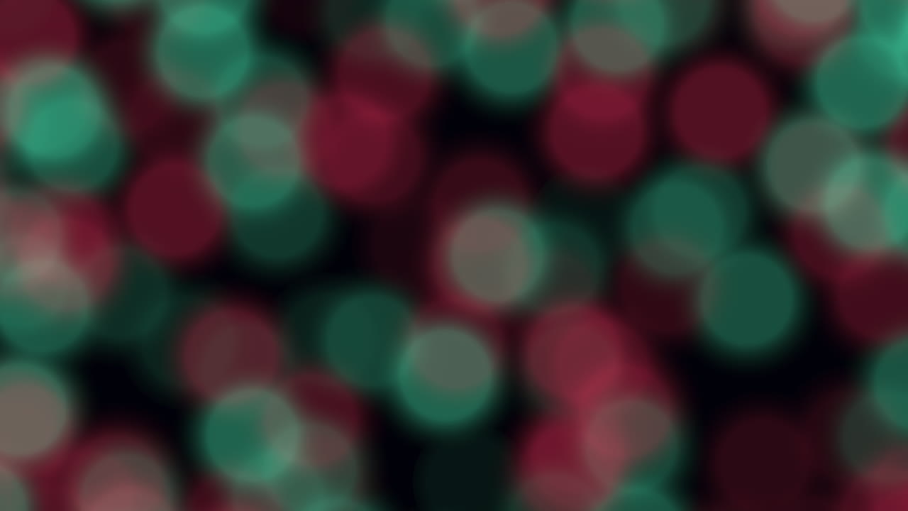 Filmato bokeh festivo astratto con cerchi di luce rossi e verdi che si muovono delicatamente su uno sfondo scuro. Ideale come sfondo per vacanze, feste o celebrazioni, per titoli, overlay e motion design.