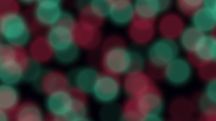 Abstract festive bokeh footage with softly moving red and green light circles on a dark background. Ideal as a holiday, party or celebration backdrop for titles, overlays and motion design