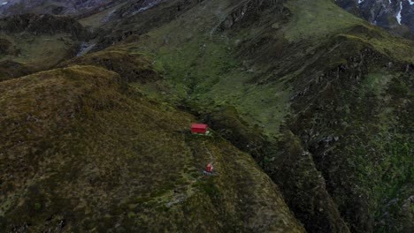 Mount-Aspiring-National-Park,-New-Zealand---Remote-Hut-in-Beautiful-Mountain-Landscape,-Aerial-Tilt-up