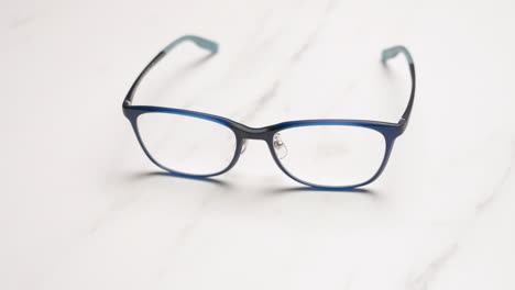 zoom out of blue prescription glasses on table in light color