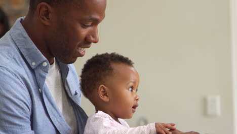 father and baby daughter using laptop at home together