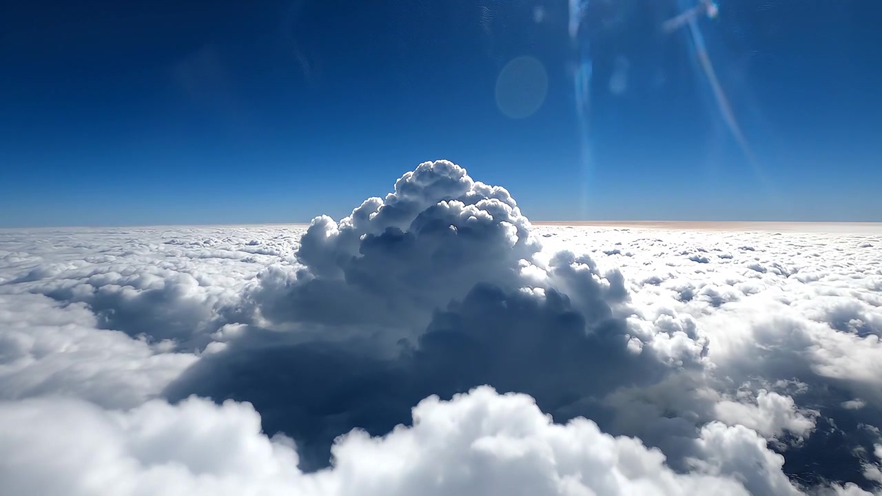 Aerial view of towering cumulus clouds above a cloud deck