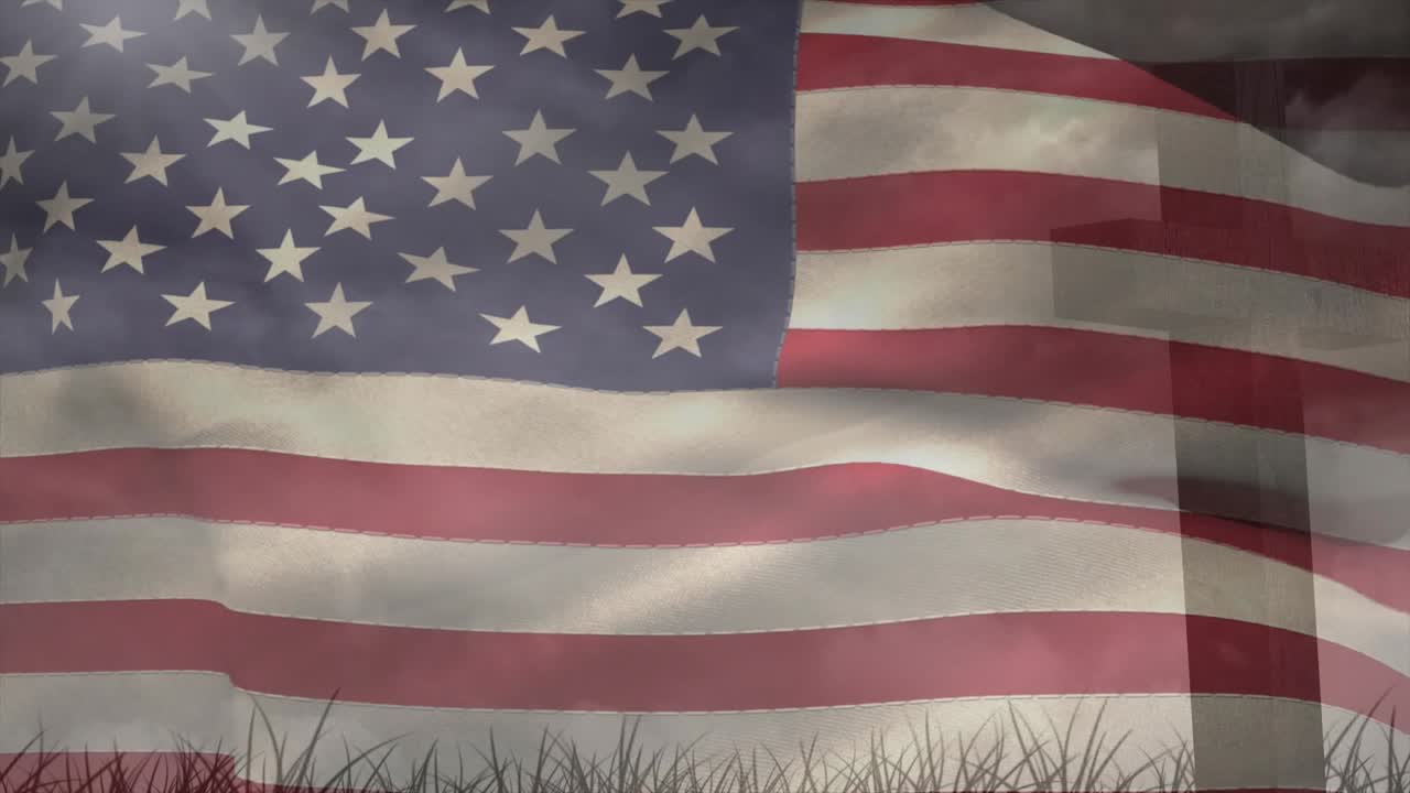 Mild bris fanger et amerikansk flagg på en flaggstang, og får stoffet til å bølge over gress-silhuetter.