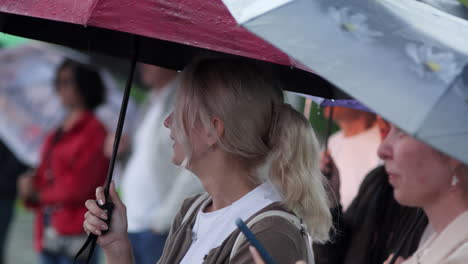 women with umbrellas in the rain