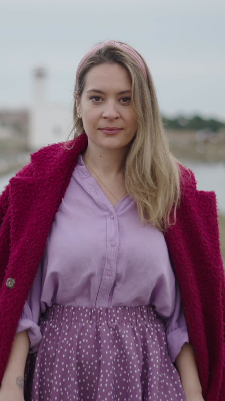 Woman in pink coat and purple dress