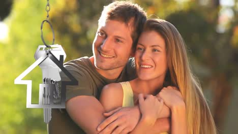 House-keys-and-key-fob-hanging-with-smiling-couple-in-the-background