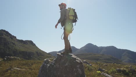 young caucasian man standing on a rock