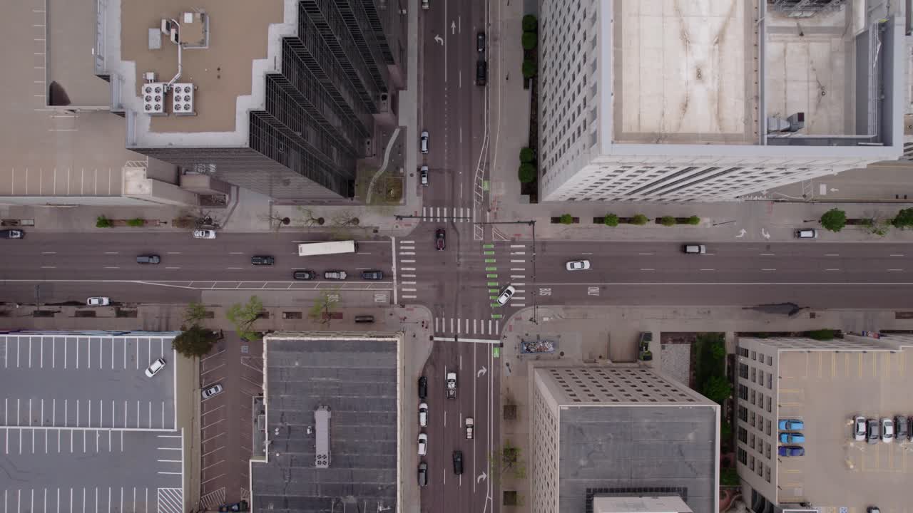 Drone descent to intersection in big city with tall buildings