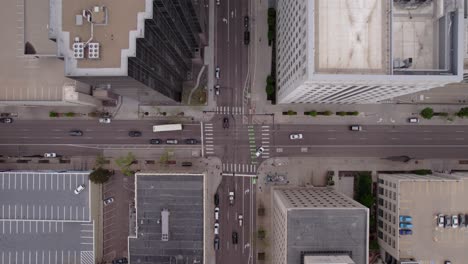 Drone-descent-to-intersection-in-big-city-with-tall-buildings