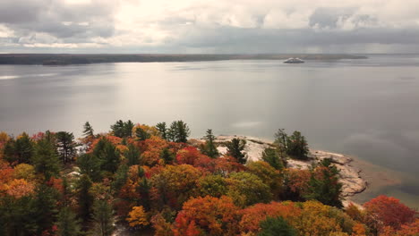 aerial view of a calm bay with banks full of colorful autumn trees