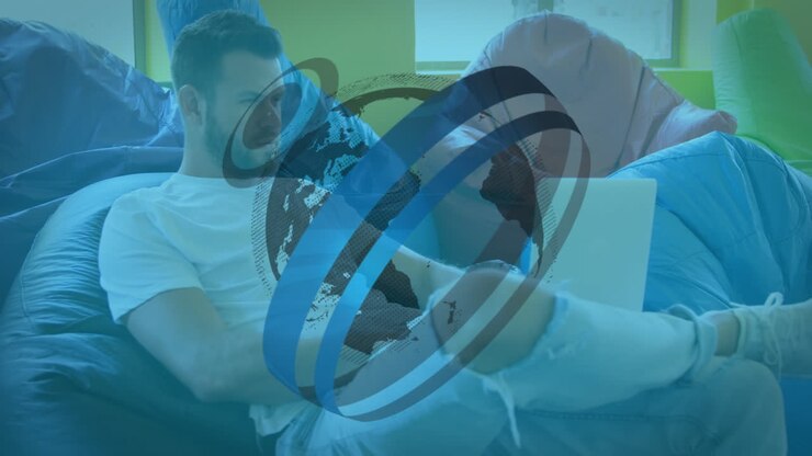 Animation of graphical globe rotating over caucasian male boss working over laptop on beanbag
