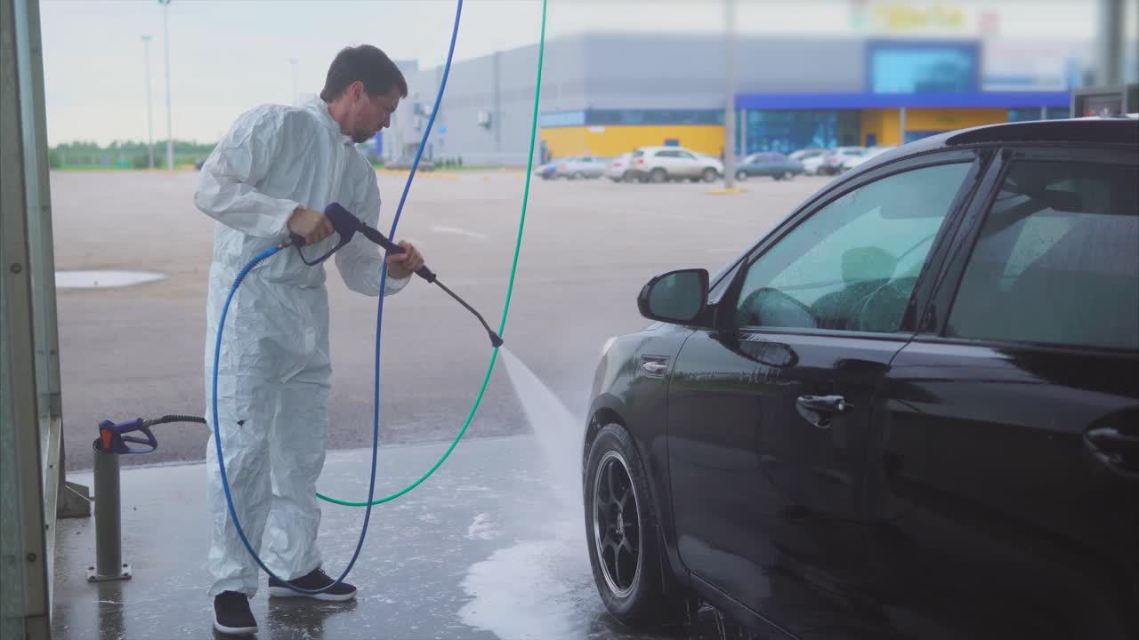 Person Washing a Black Car at a Car Wash