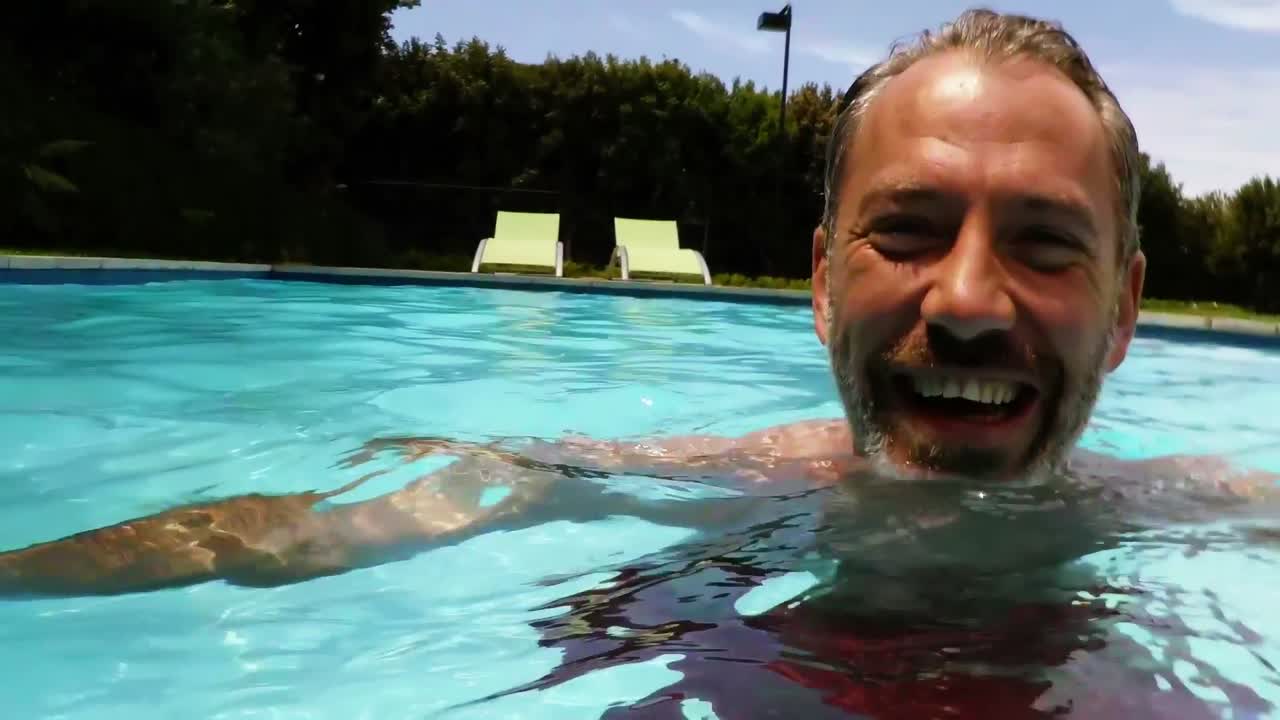 retrato de un hombre feliz nadando en la piscina