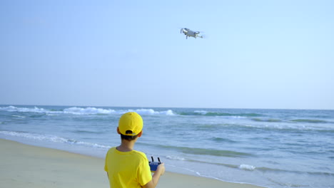 boy flying a drone in beach side