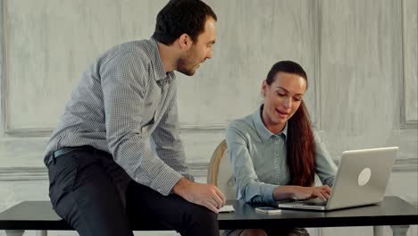 hombre y mujer de negocios serios con computadora portátil en la oficina