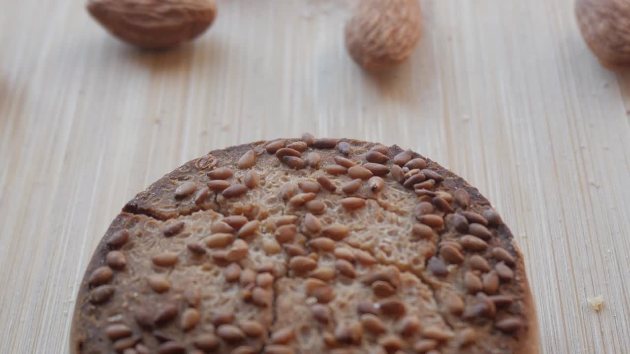 традиционный испанский рождественский сладкий мантекадо с семенами орехами сверху, помещенный на деревянную поверхность, крупный вид