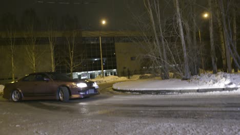 coche púrpura a la deriva en un camino nevado por la noche
